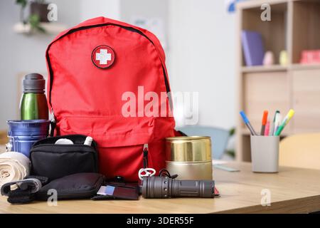 Emergency backpack with necessities on table in classroom Stock Photo