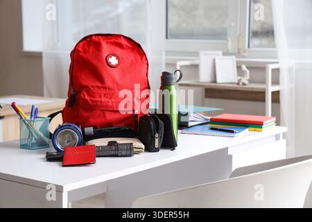 Emergency backpack with necessities on table in classroom Stock Photo