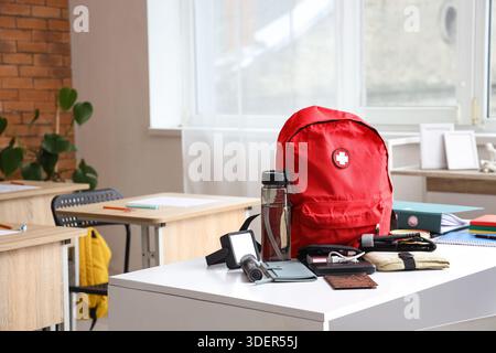 Emergency backpack with necessities on table in classroom Stock Photo