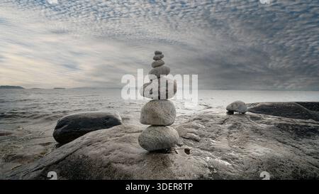 Stacked Rocks balancing, stacking with precision. Stone tower on the shore. Stock Photo