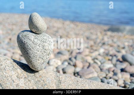 Stacked Rocks balancing, stacking with precision. Stone tower on the shore. Stock Photo