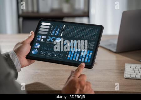 man with Chart businessman reviewing management data as a man tracks chart growth, profit, statistic, and success through business analytics on a tabl Stock Photo
