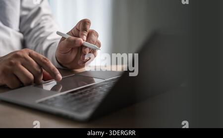 work from home office use the internet working on laptop computer sitting at office desk and working from home having work space Stock Photo