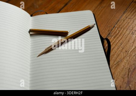 Open Blank Notebook with Broken Pencil on Worn Wooden Surface Symbolizing Writer's Block Stock Photo