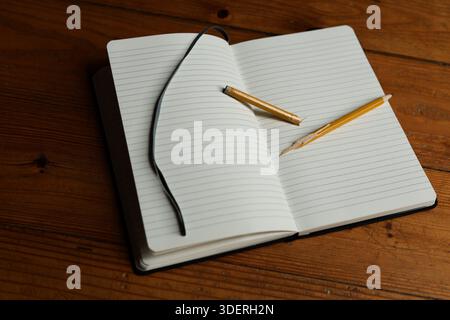 Open Blank Notebook with Broken Pencil on Worn Wooden Surface Symbolizing Writer's Block Stock Photo