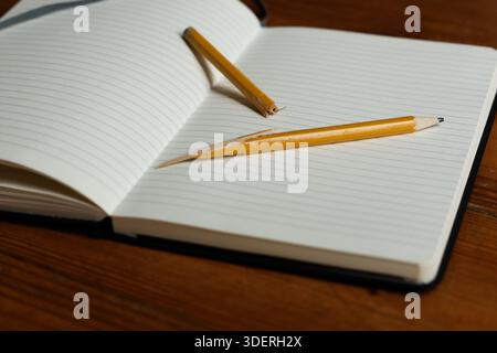 Open Blank Notebook with Broken Pencil on Worn Wooden Surface Symbolizing Writer's Block Stock Photo
