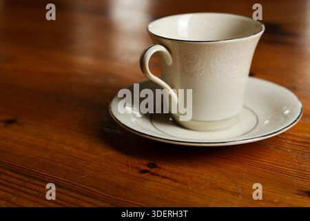 Fine Porcelain Teacup and Saucer on Worn Wooden Surface Stock Photo