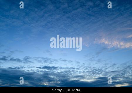 A serene view of a bright blue sky filled with fluffy white clouds, ideal for relaxing and peaceful backgrounds Stock Photo