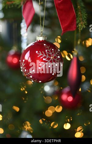 Red sparkly bauble on tree Stock Photo