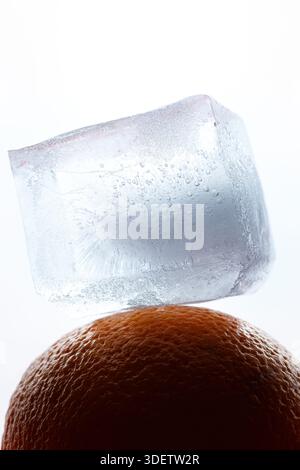 A piece of ice lies on an orange like art Stock Photo