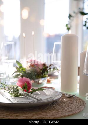 Wedding table decorated with pink roses. Festive set table for a wedding dinner. Bright, elegant restaurant background with short depth of field. Stock Photo