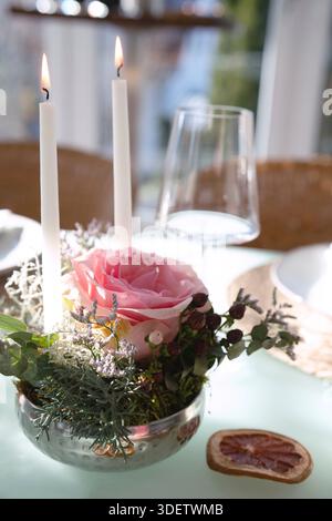 Wedding table decorated with pink roses. Festive set table for a wedding dinner. Bright, elegant restaurant background with short depth of field. Stock Photo