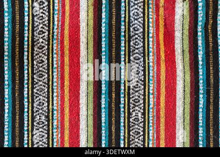 Nepalise or mexican tribal style woollen blanket pattern. Colourful lines of red, blue, yellow and black. Vertical lines texture woven from brushed co Stock Photo