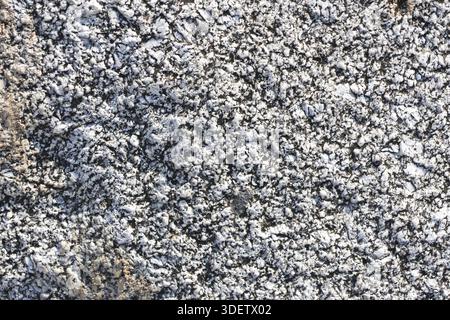 Texture of crushed grey stone and granite gravel pattern lying on ground for construction road decoration showing rough abstract rocky surface with na Stock Photo