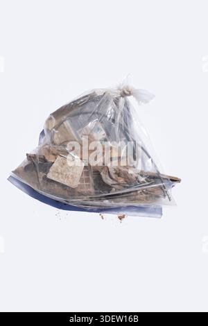 Clear bag of trash on solid white backdrop Stock Photo