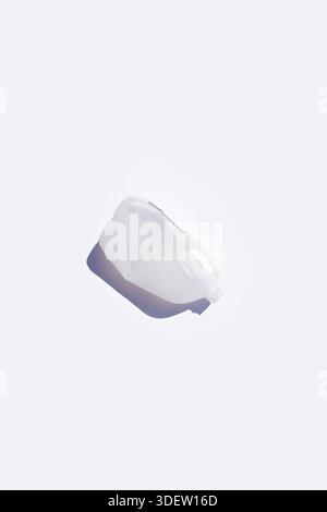 Discarded frosted plastic jug on solid white background Stock Photo