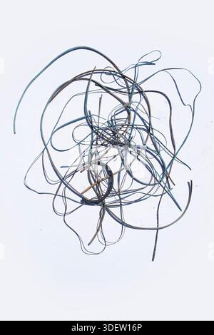 Nest of discarded loose wires on soldi white backdrop Stock Photo