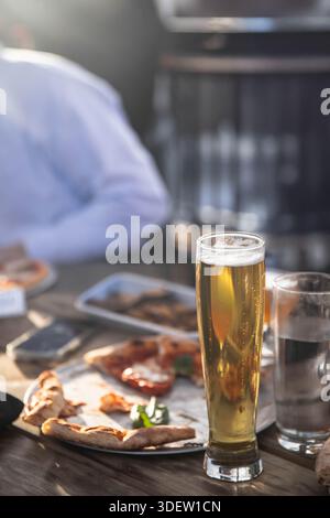 Enjoying beer and pizza with friends dining out Stock Photo