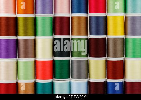 Colored spools of thread in an orderly row. Stock Photo