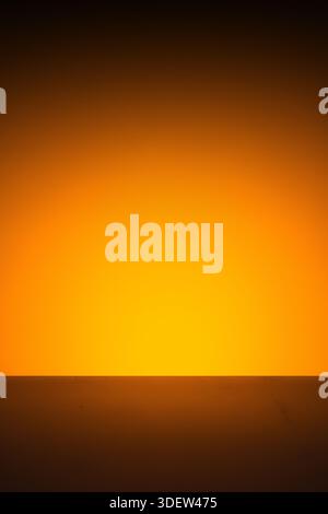 Abstract orange light glow on dark horizontal surface background. Stock Photo