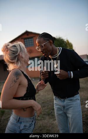 young couple dancing outside at sunset Stock Photo