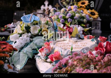 Grave decorations made from artificial flowers in Croatia. Traditionally, artificial flowers or silk arrangements are used on graves rather than real ones. Close-up Stock Photo