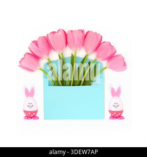 Pink Easter springtime tulip flower gift with blue envelope on white background with bunny rabbit eggs. Surreal abstract design surprise . Stock Photo