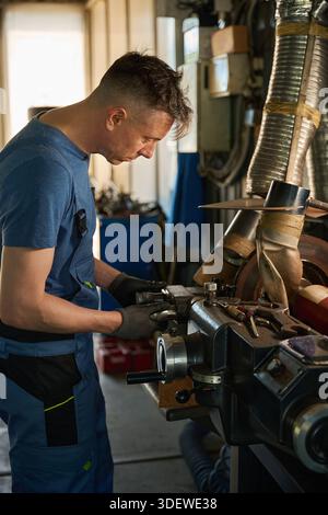 Mechanic works with a car in the workshop Stock Photo