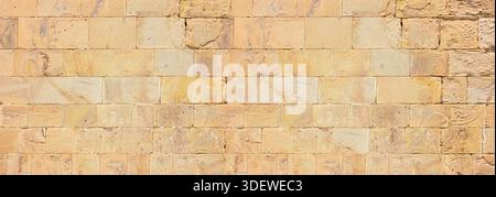 Sandstone wall displaying weathered blocks and textured brickwork suitable as a background Stock Photo