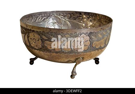 Antique silver metal bowl features intricate embossed floral patterns, sitting on tripod feet with a transparent background Stock Photo