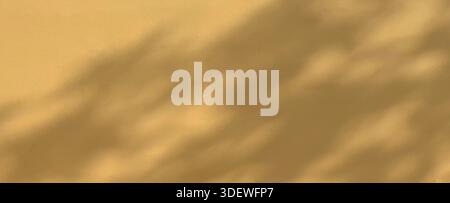 Gentle sunlight casts abstract shadows across a warm beige textured wall Stock Photo