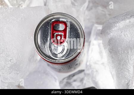 Top View of Chilled Drink Can with Red Pull Tab in Ice Stock Photo