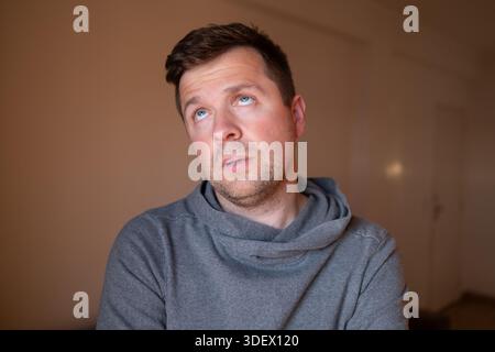 Skeptical male person reacting to a lie or stupid question, looking bored and fed up. Stock Photo