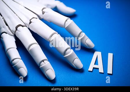 Robot hand and AI lettering, symbolic photo of artificial intelligence and robot technology Stock Photo