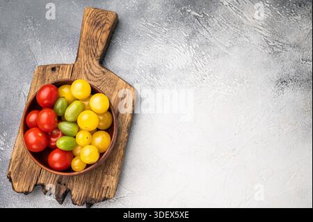 Fresh small red, green and yellow cherry tomatoes assortment, mini organic cocktail tomate mix. white background. top view. Stock Photo