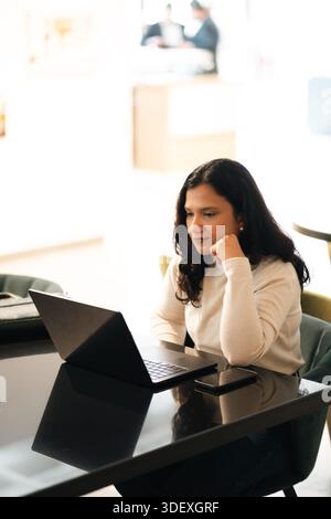 woman entrepreneur working on laptop in office, businesswoman in Dubai, vertical image Stock Photo