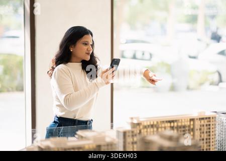 woman Real estate agent in Dubai showing new project launch to foreign clients on video call Stock Photo
