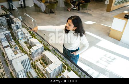 Real estate agent showing architectural model of Off-plan property to clients, Property investment planning with architectural scale model Stock Photo