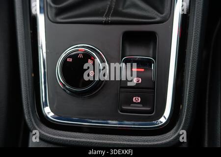 A close up of an electronic parking brake button on a car center console highlights modern vehicle safety features, driver convenience, and advanced a Stock Photo