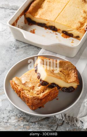 Far Breton is a classic French dessert, a rich, dense custard with dried fruit and rum closeup on the plate on the table. Vertical Stock Photo