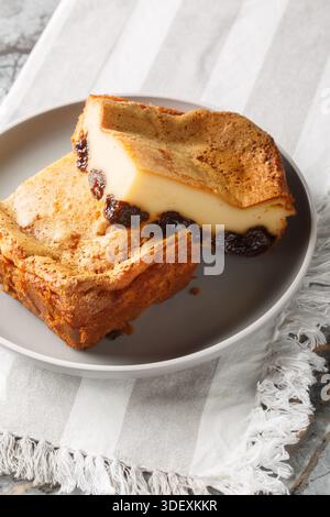 French far breton a pudding with prunes and rum closeup on the plate on the table. Vertical Stock Photo