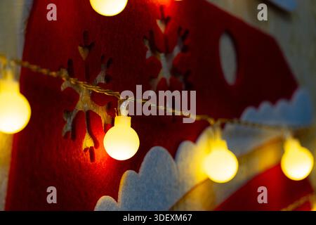 Cozy festive decoration with glowing string lights and felt snowflakes. Perfect for winter and holiday themes Stock Photo