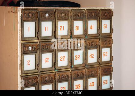 Chambord, Canada - August 18, 2025: Vintage brass post office boxes (numbered 1-55) inside the post office at Val-Jalbert Historical Village Stock Photo