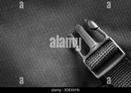 Black plastic fastex strap over black fabric background Stock Photo