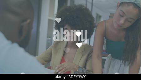 Reviewing woman with curly hair handling paperwork at office table, in tan blazer, heart overlays Stock Photo