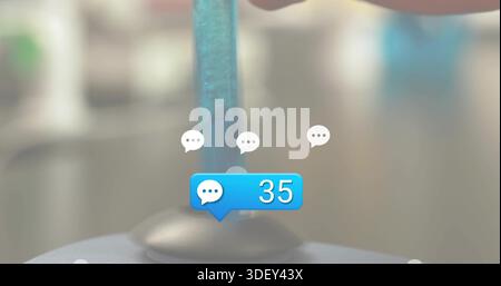 Displaying blue chat notification bubble showing 35 with clear rod and suction base on desk, bokeh Stock Photo