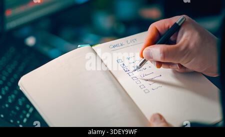 Checklist notebook task planning productivity. Closeup hand marking completed items paper journal pen focus workflow organization time management busi Stock Photo