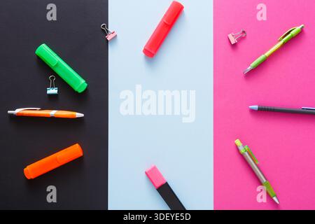 Colorful School Supplies Arranged on Three Different Colored Backgrounds in a Flat Layout Stock Photo