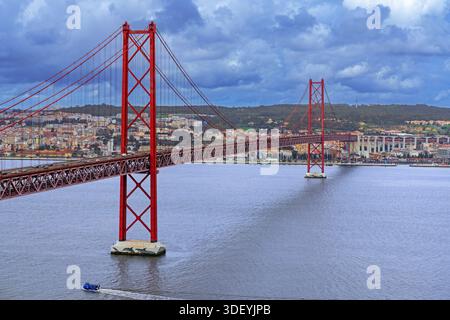 Ponte 25 de Abril / 25th of April Bridge, red suspension bridge over the Tagus River connecting the city of Lisbon / Lisboa to Almada, Portugal Stock Photo