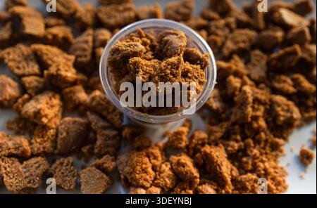 Crushed gingerbread cookies in and around a clear plastic cup Stock Photo